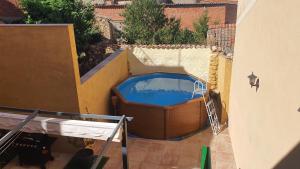 a swimming pool with a hot tub next to a building at La Centralita de la Abuela in Segovia