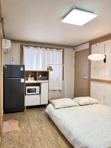 a kitchen with a bed and a refrigerator in a room at Daegu Gyeongsan Stay in Gyeongsan +112 photos