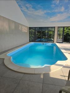 a large blue swimming pool in a building with windows at Casa Hirsch in Avrig
