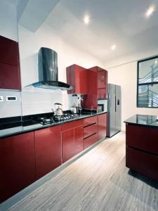 a kitchen with red cabinets and stainless steel appliances at TheHubCentral in Lekki