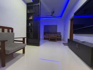 a living room with a tv and a couch at Coral Shores villa in Varkala