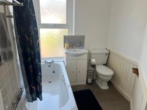 Un baño con inodoro, bañera y lavabo. en 101 - Room 2 - Uplands, en Sketty