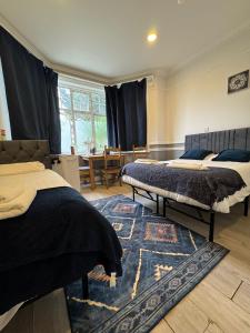 a bedroom with two beds and a dining room with a table at Golders Park Hotel in London