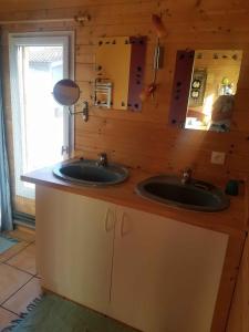 a bathroom with two sinks and a mirror at Yvrac chambre d'hôtes indépendante in Yvrac