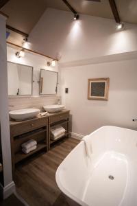 a bathroom with a white tub and two sinks at Yorebridge House in Bainbridge +25 photos