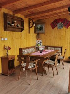 a dining room with a wooden table and chairs at Casa de vacanta 1001 De Nopti in Corbşori