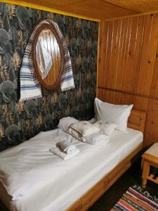 a bed in a room with towels on it at Casa de vacanta 1001 De Nopti in Corbşori