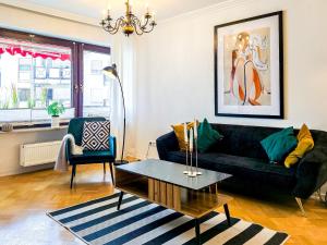 a living room with a black couch and a table at SCANDiC-Apartment - Balkony & Garage, 3Z, 80m2 in Pforzheim