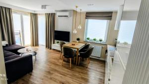 a living room with a table and a couch at Baltic Breeze Apartamenty in Kołobrzeg