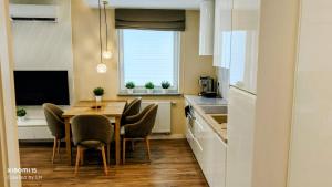 a kitchen with a table and chairs in a room at Baltic Breeze Apartamenty in Kołobrzeg
