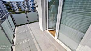a balcony with a window with blinds on it at Baltic Breeze Apartamenty in Kołobrzeg