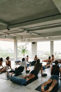 a group of people sitting in a yoga class at Salty Prana Retreat Center in Uluwatu