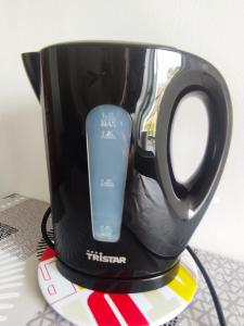 a black coffee mug with a remote control in it at Gite des Mézières in Brusvily