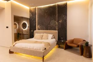 a bedroom with a bed and a chair at Sea Suites - סוויטות מהממות עם מרפסת ליד המרינה באשקלון in Ashqelon