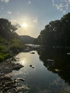 a river with the sun reflecting in the water at Camping Beaussement Samouraï in Chauzon +2 photos