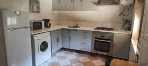 a small kitchen with a washer and a sink at Boa Fé Home Elvas in Elvas