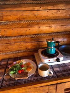 a table with a plate of food and a cup of coffee at Затишна хата in Huklyvyy