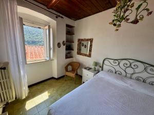a bedroom with a white bed and a window at Casa i capperi in Marciana
