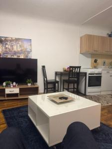 a living room with a white coffee table and a kitchen at Retals Stuttgart City in Stuttgart