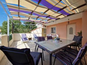 a patio with a table and chairs on a patio at VILLAGE apartment in Zagvozd +23 photos
