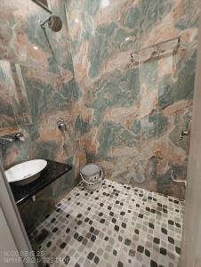 a bathroom with a sink and a tiled wall at Hotel Divaa Inn in Mathura