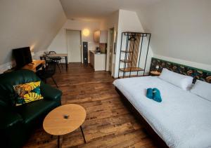 a bedroom with a bed and a couch and a table at Domstadt Apartments in Merseburg
