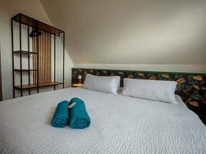 a bed with two pairs of blue slippers on it at Domstadt Apartments in Merseburg
