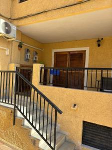 Una escalera que conduce a un edificio con balcón. en Apartamento en la playa, en La Mata