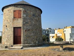an old stone building with a wooden door at In Apúlia - Moinho do Mar in Apúlia