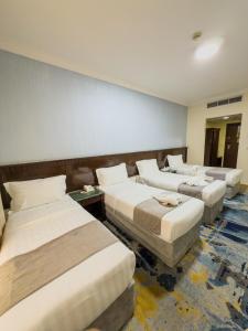 una habitación con tres camas y un sofá en فندق سبال بلس - Sebal plus hotel, en Medina