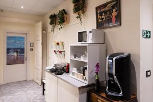 a kitchen with a counter top with a microwave and a television at Rooms Boutique Carducci in Trieste