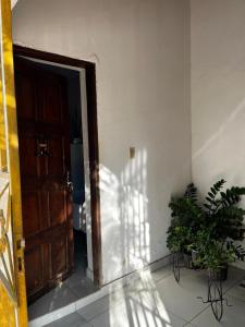 an open wooden door in a room with plants at Refúgio aconchegante no coração da cidade in Carolina