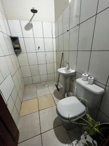a bathroom with a toilet and a sink at Refúgio aconchegante no coração da cidade in Carolina