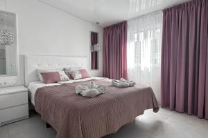 a bedroom with a large bed with pink curtains at Fantastic vacation by the ocean in Playa de las Americas +49 photos