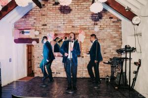 Eine Gruppe Männer steht vor einer Backsteinmauer in der Unterkunft Large Country Home, Lake, Bar, Fire Hut, Sleeps 16 plus in Hillsborough