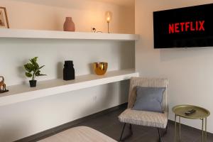 a waiting room with a chair and a sign that reads netflix at Le Majestueux Calme Central Chic in Le Creusot