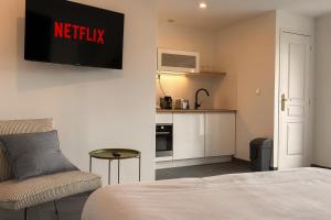 a hotel room with a bed and a kitchen at Le Majestueux Calme Central Chic in Le Creusot