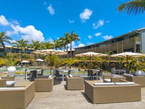 a resort with tables and chairs and umbrellas at Be Cosy by LOV Mauritius in Trou aux Biches