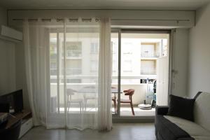 a living room with a sliding glass door with a table at Arcachon les pieds dans l'eau in Arcachon