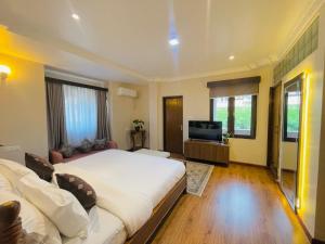 Un dormitorio con una cama grande y un televisor. en Devi Aura Villa, en Burhānilkantha