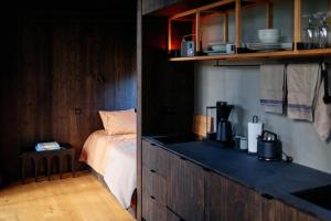 a bedroom with a bed and a kitchen with a counter at Architect-Designed Cabin In Söderhamn Archipelago in Söderhamn +30 photos