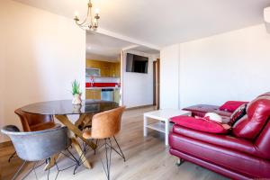 a living room with a red couch and a table at Sunset Palm Mar - Family Friendly Suites in Palm-Mar