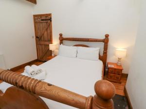 a bedroom with a wooden bed with two lamps at Bruno's Bothy in Belford