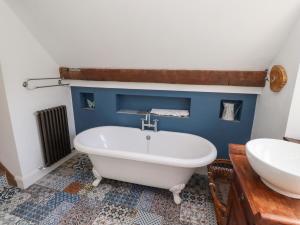 a bathroom with a white tub and a sink at Bruno's Bothy in Belford +43 photos