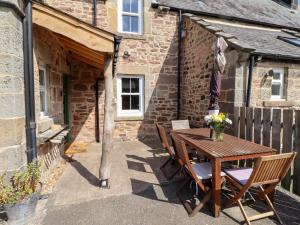 a wooden table and chairs in front of a building at Bruno's Bothy in Belford