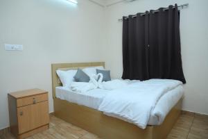 a bedroom with a bed with a black curtain at The Pent House in Ernakulam