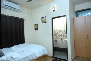 a bedroom with a bed and a bathroom with a shower at The Pent House in Ernakulam +3 photos