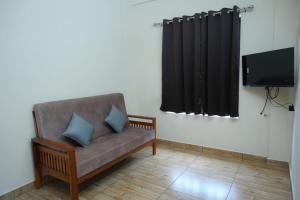 a living room with a couch and a flat screen tv at The Pent House in Ernakulam
