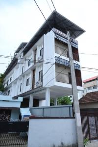 a white building with a fence in front of it at The Pent House in Ernakulam