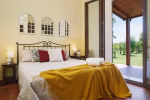a bedroom with a bed with a yellow blanket on it at Country House With Pool Among Noto Citrus Groves in Noto